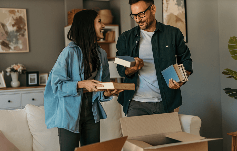 A man and a woman sorting books into boxes.png