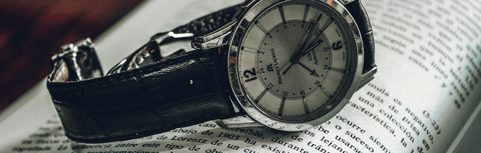 A valuable watch resting on an open book, header image.png