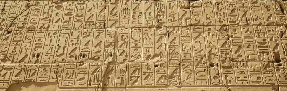 Ancient Egyptian hieroglyphs carved into stone.png