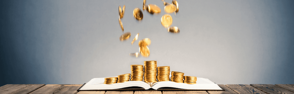 Gold coins falling onto an open secondhand book.png