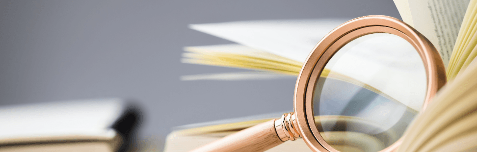 Inspecting a secondhand book with a magnifying glass.png