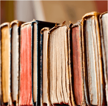 Row of worn hardback book spines, showing varied condition to sell to WeBuyBooks