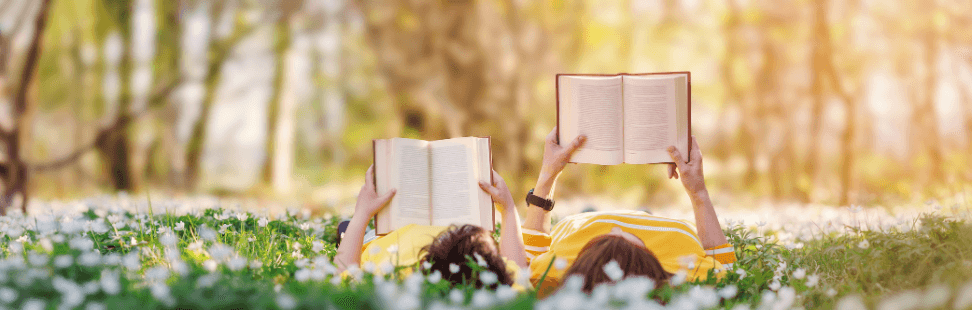 Mother and son lying in a field of flowers with reading books.png