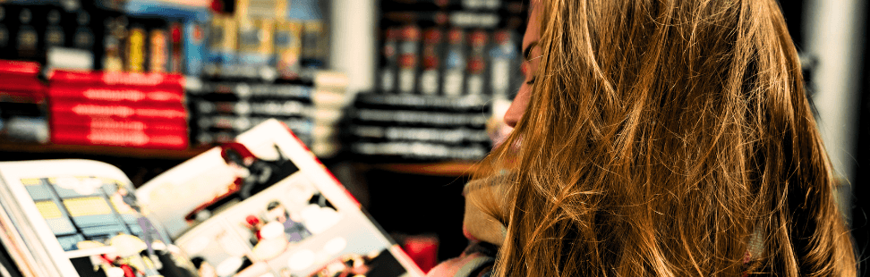 Woman reading a comic book in a comic book shop.png