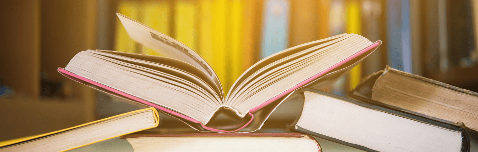 a second-hand textbook on a pile of other books.png