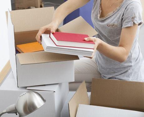 Woman packing books into a box, ready to sell her unwanted books online