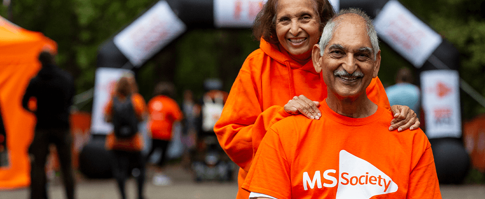 two people wearing MS Society charity t-shirts outside.png